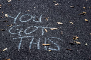 Tarmac with leaves and white chalk writing "Yo Got This"