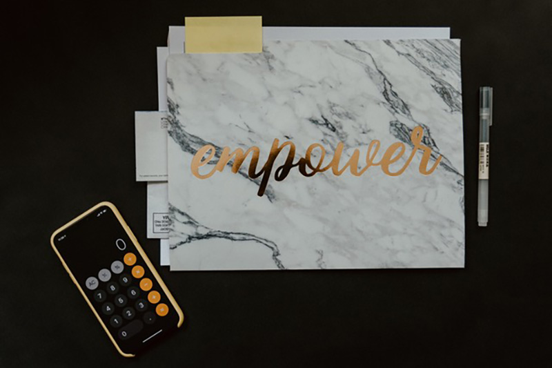 Desktop organiser with calculator and the words "Empower" on a pad