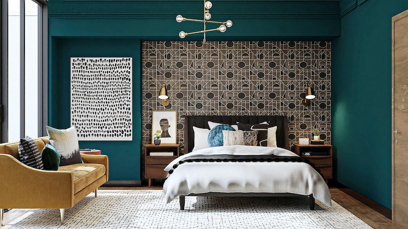 bed in room with teal walls and mustard chair