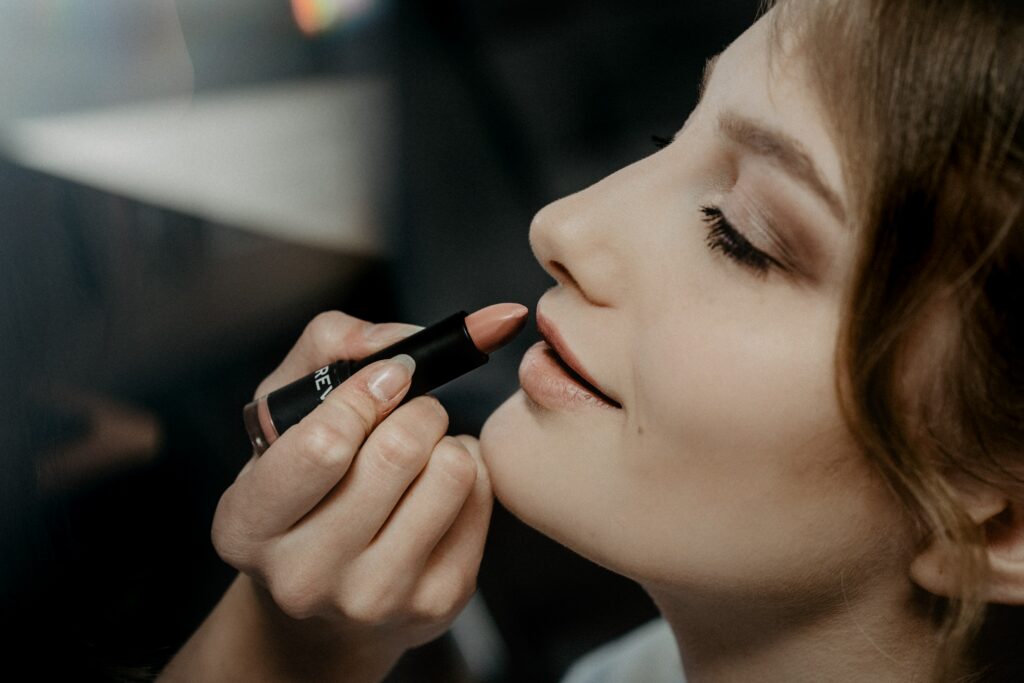 makeup artist applying lipstick on to woman